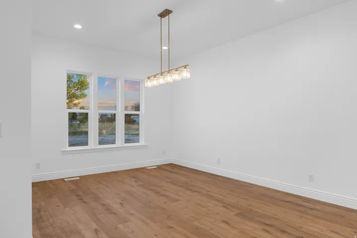 Unfurnished dining area featuring wood finished floors and hanging lights