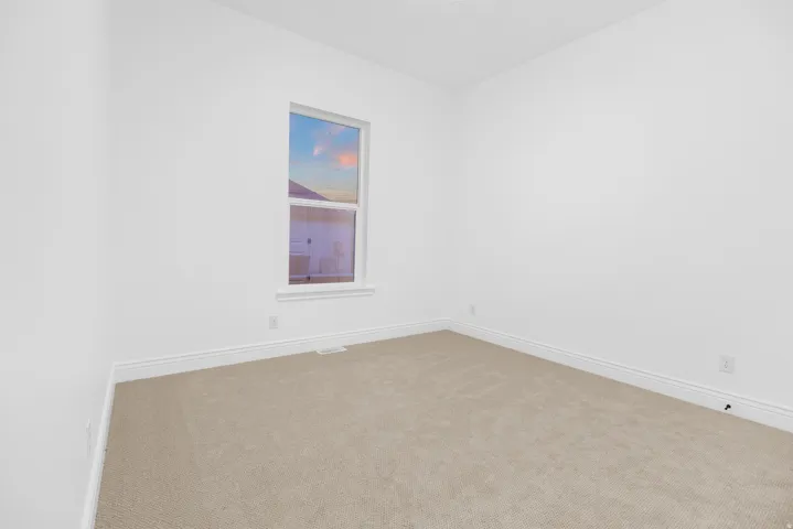 Carpeted spare room featuring baseboards