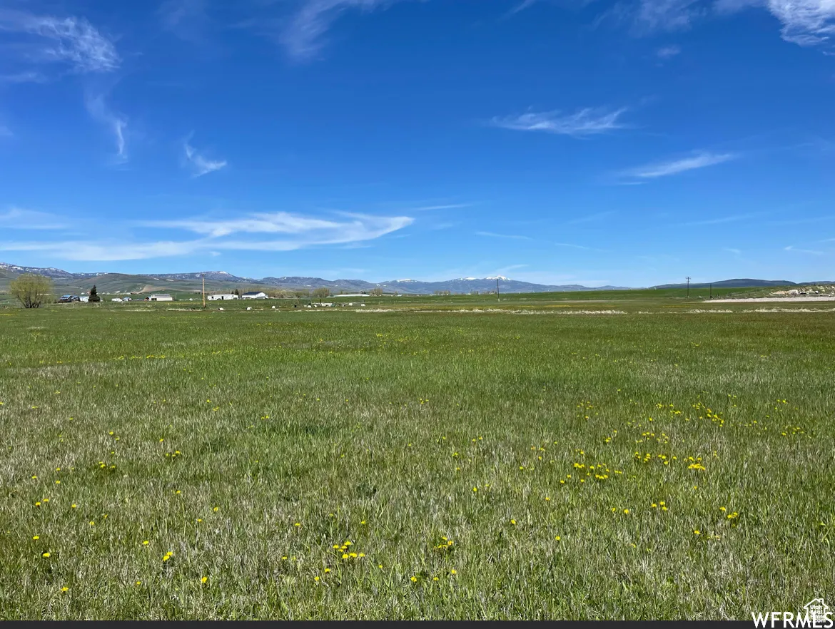 View of undeveloped land featuring a mountain backdrop and rural landscape