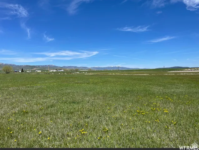 View of undeveloped land featuring a mountain backdrop and rural landscape