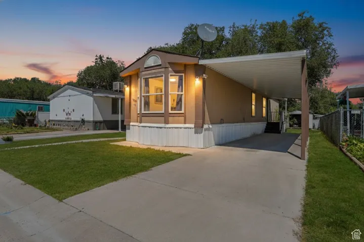 Mobile home featuring driveway and an attached carport