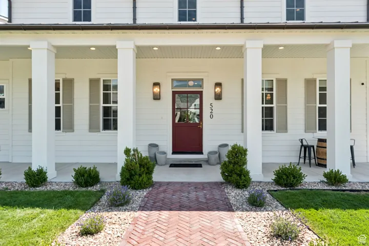 Property entrance with covered porch and a yard