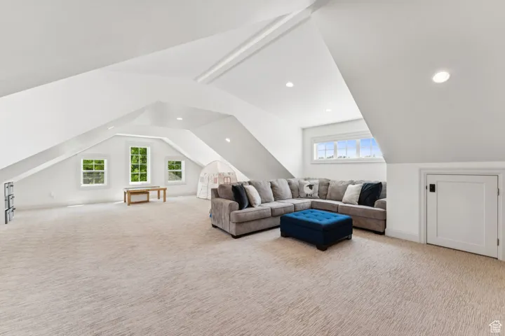 Living area featuring vaulted ceiling, carpet, and recessed lighting