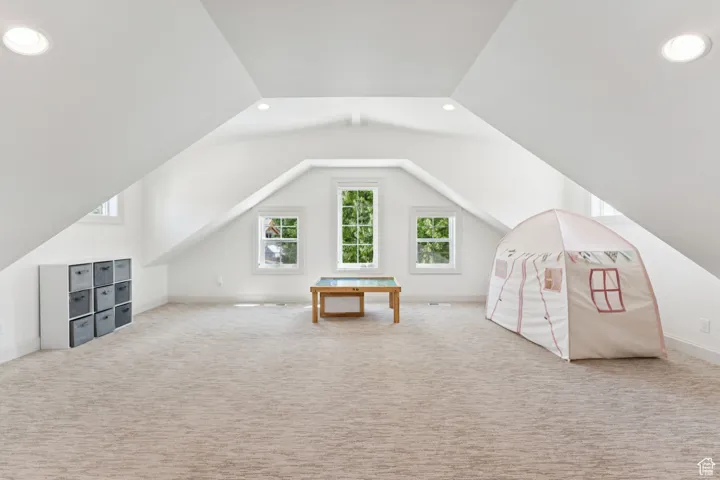 Additional living space featuring carpet flooring, vaulted ceiling, and recessed lighting