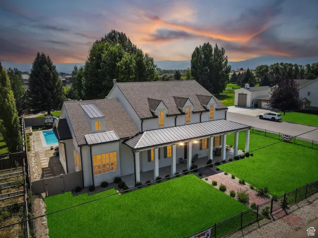 Modern farmhouse style home with a porch, roof with shingles, a standing seam roof, a metal roof, and a gate