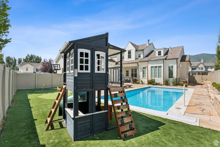 Rear view of house featuring a fenced backyard and a patio