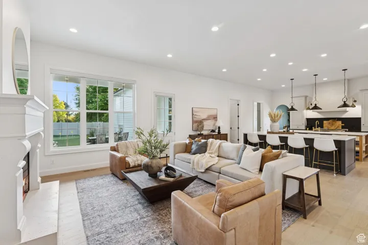 Living area featuring recessed lighting, light wood-style floors, and a premium fireplace