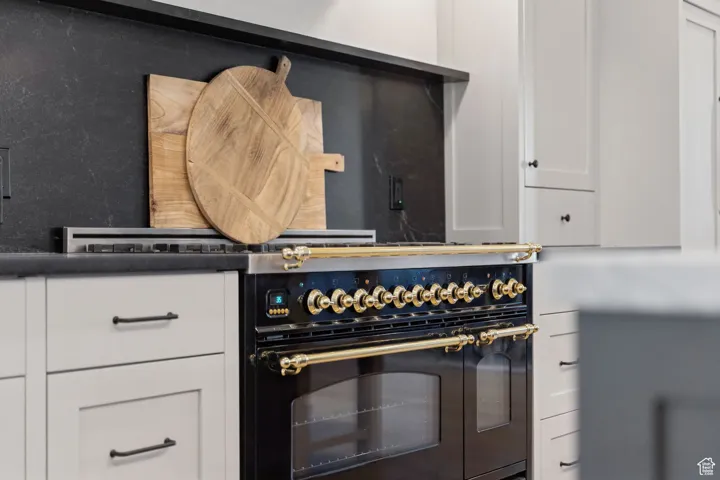 Kitchen featuring white cabinets and double oven range