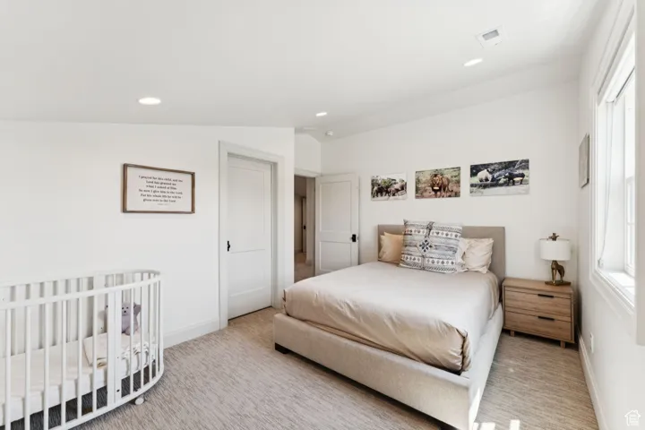 Bedroom featuring a nursery area, carpet flooring, and recessed lighting