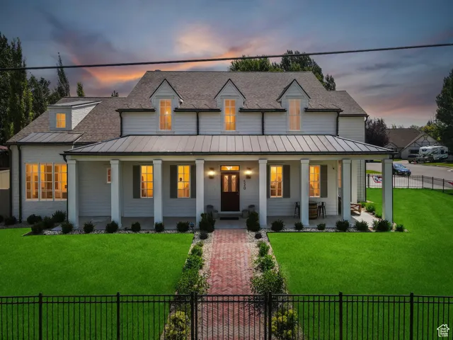 Modern inspired farmhouse featuring a fenced front yard, a porch, and a shingled roof