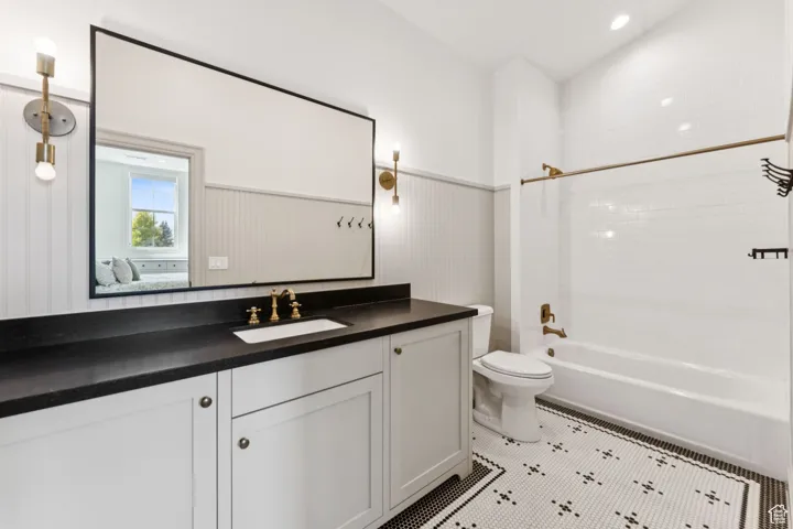 Ensuite bathroom featuring shower / washtub combination, vanity, and light tile patterned floors
