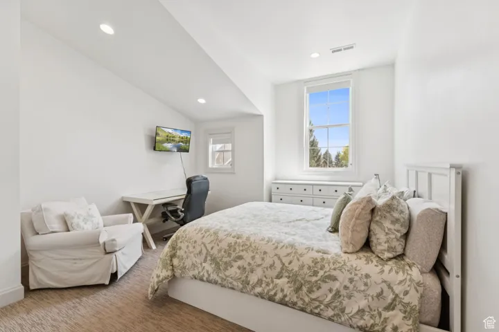 Carpeted bedroom with recessed lighting and lofted ceiling