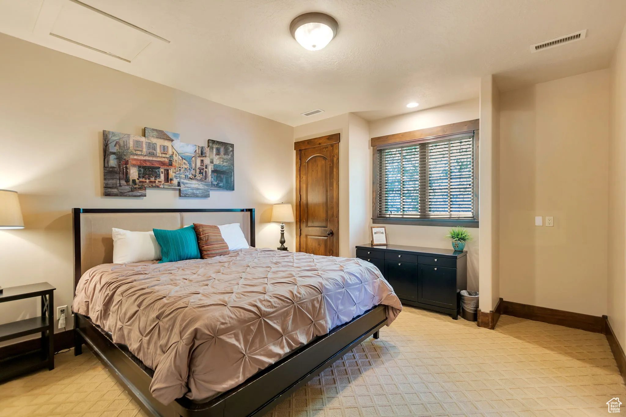 Bedroom featuring attic access, light colored carpet, and a closet