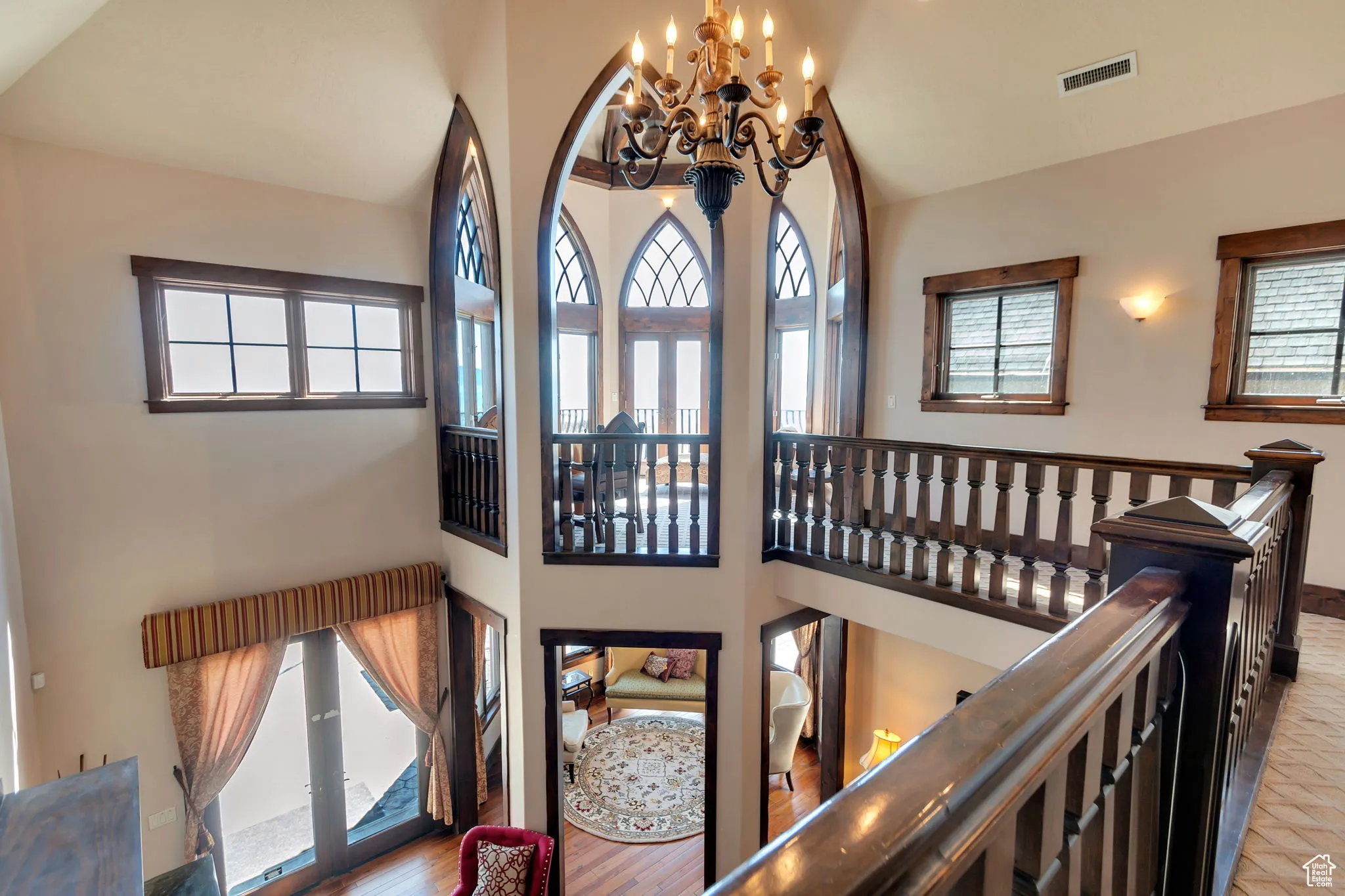 Stairway featuring a chandelier, high vaulted ceiling, wood finished floors, view of Turret.