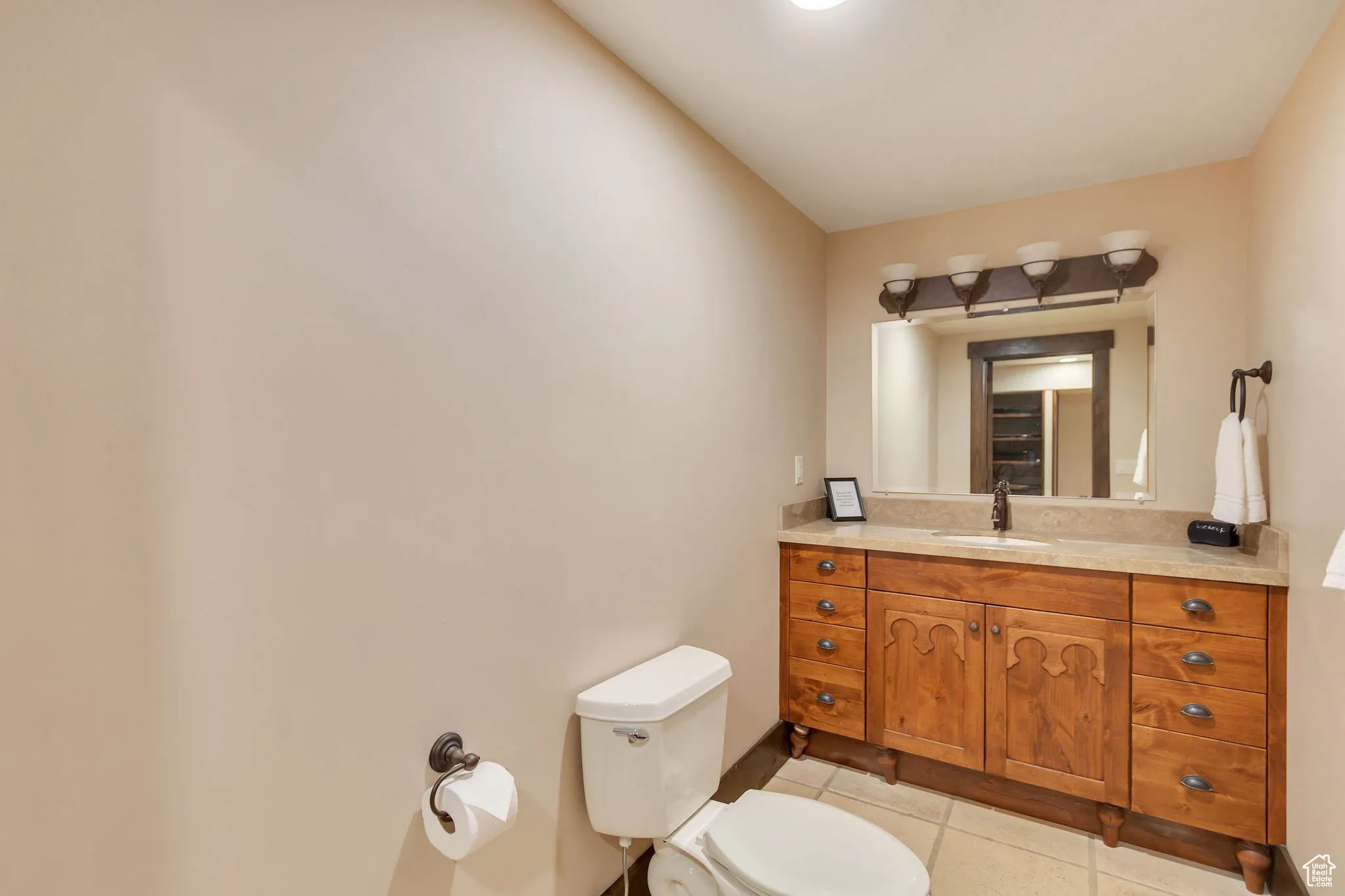 1/2 Bathroom featuring light tile patterned floors and vanity