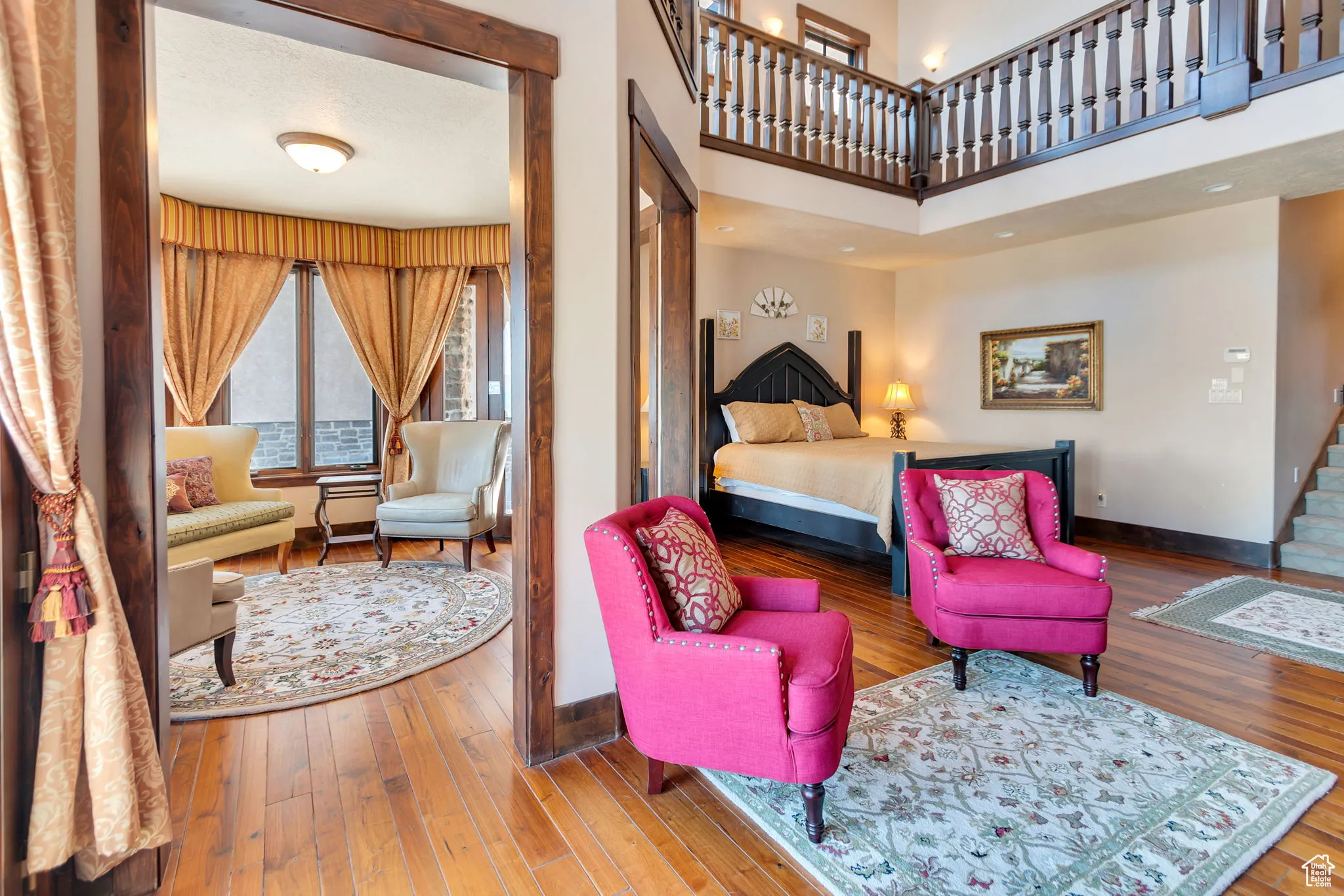 Primary Bedroom with hardwood / wood-style floors sitting room and a high ceiling