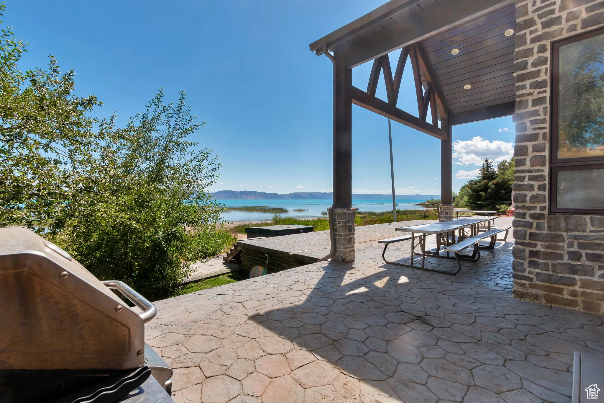 View of patio featuring a water and mountain view, outdoor dining area, and area for grilling