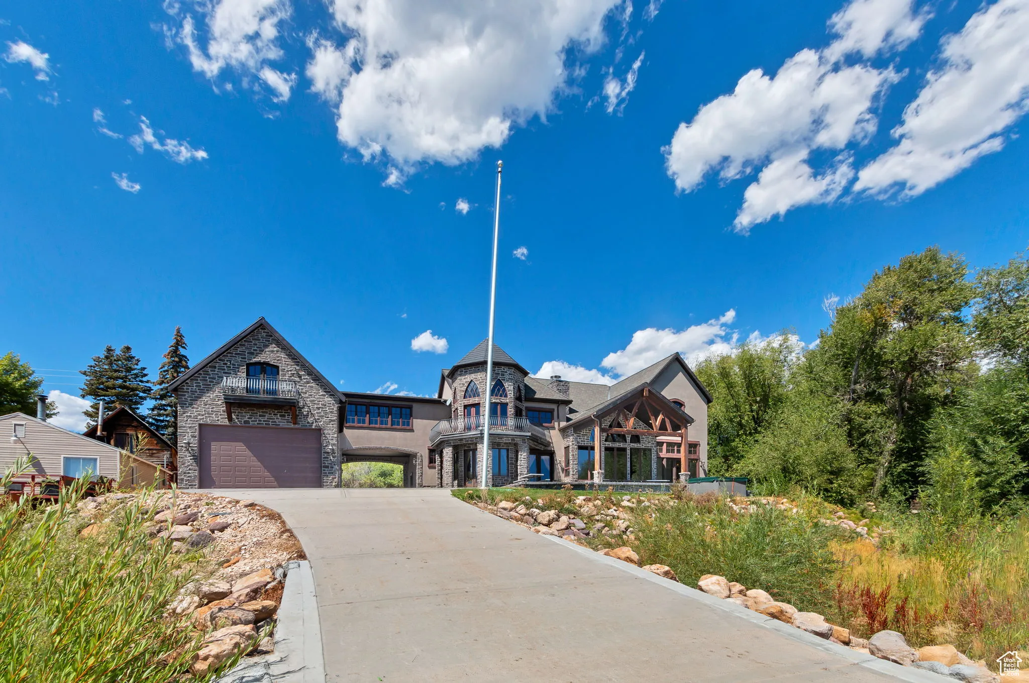 View of front of home featuring stone siding and driveway
