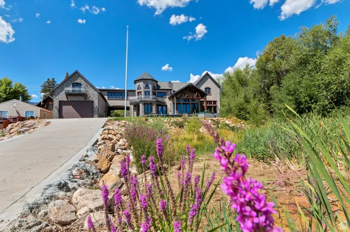 View of front of home with stone siding, concrete driveway, and a garage