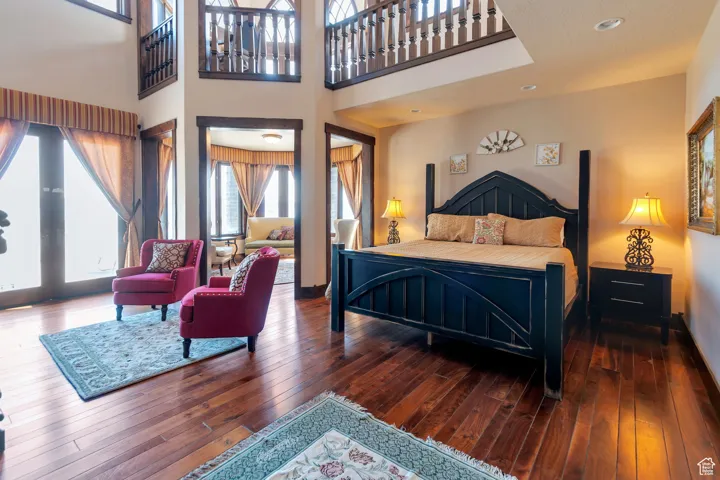 Primary Bedroom with a towering ceiling, dark wood-type flooring, and recessed lighting, Sitting room and fireplace with Mantle imported from Europe.