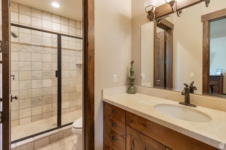 Full bathroom featuring a shower stall, vanity, and light tile patterned floors