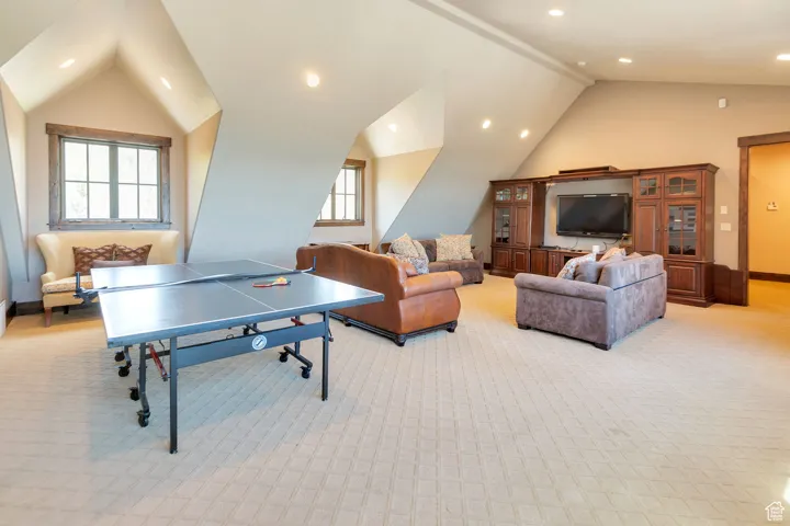Game room with recessed lighting, light carpet, and high vaulted ceiling