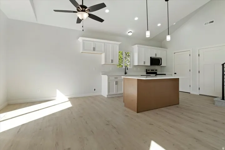 Kitchen with Quartz Countertops, Island with Pendant Lighting Over Island.