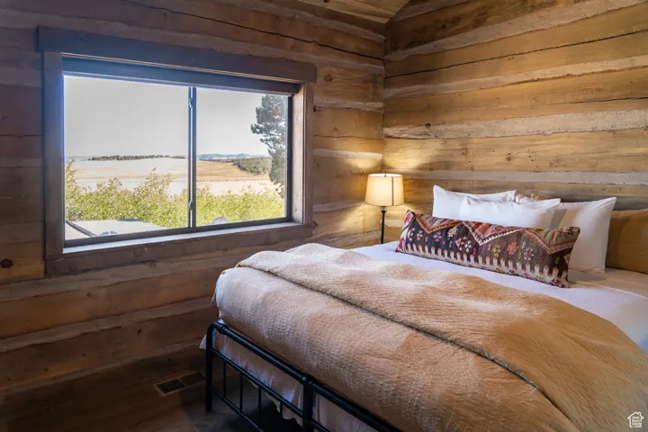 Bedroom featuring wood walls and wood finished floors