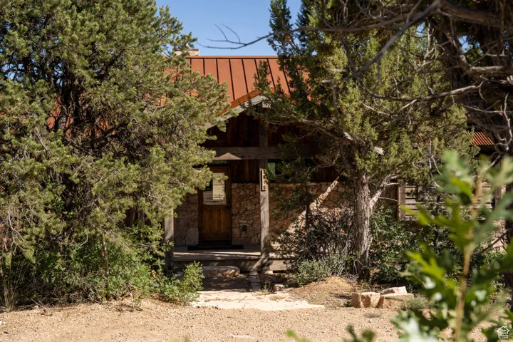View of property exterior with stone siding, a standing seam roof, and a metal roof