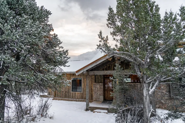 Rustic home with stone siding and a wooden deck