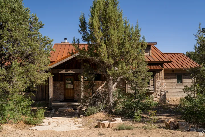 View of front of property with a standing seam roof, a metal roof, and stone siding