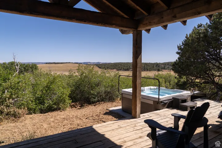 Wooden deck with a hot tub and a view of rural / pastoral area