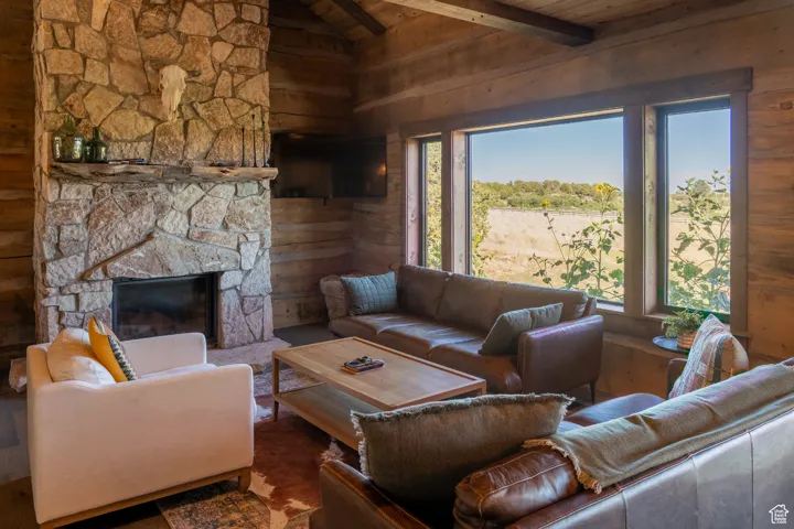 Living area featuring a fireplace, wood ceiling, and wood walls
