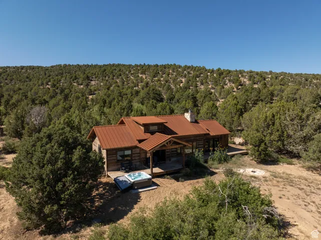 Aerial view of property and surrounding area featuring a heavily wooded area