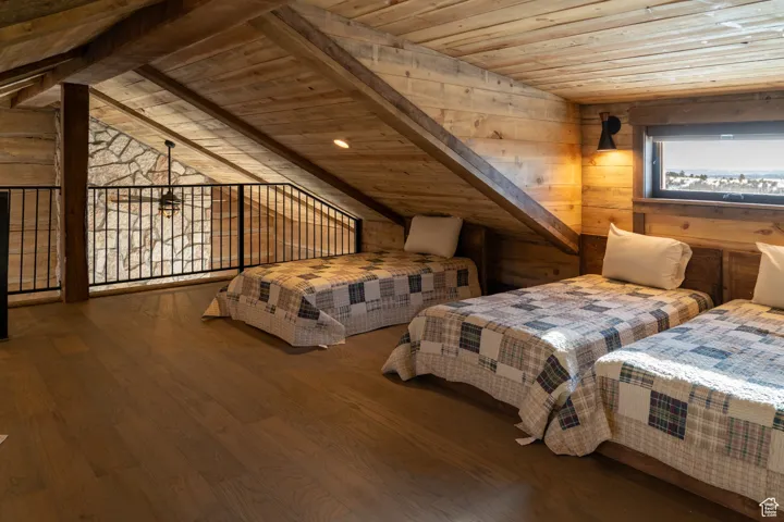 Bedroom featuring wooden walls, wooden ceiling, and wood finished floors