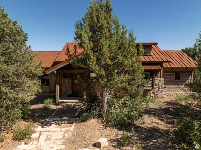 View of front of property with a metal roof, stone siding, and a standing seam roof
