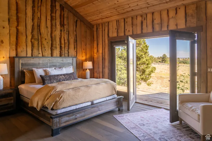 Bedroom featuring access to exterior, wood ceiling, hardwood / wood-style floors, and wood walls