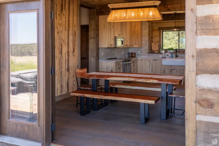 Dining room featuring dark wood-style flooring and wooden walls