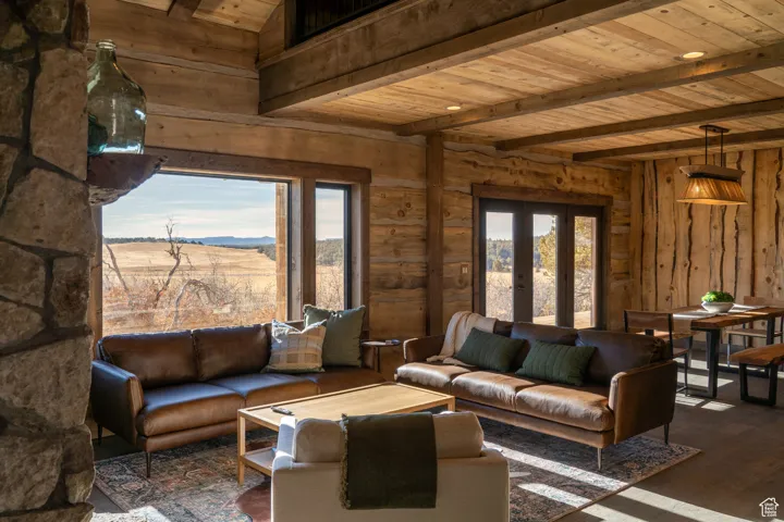 Living room with a wooden ceiling with exposed beams, french doors, dark wood-style flooring, and a mountain view
