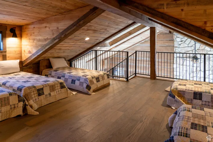 Bedroom with wooden walls, wood finished floors, and wooden ceiling