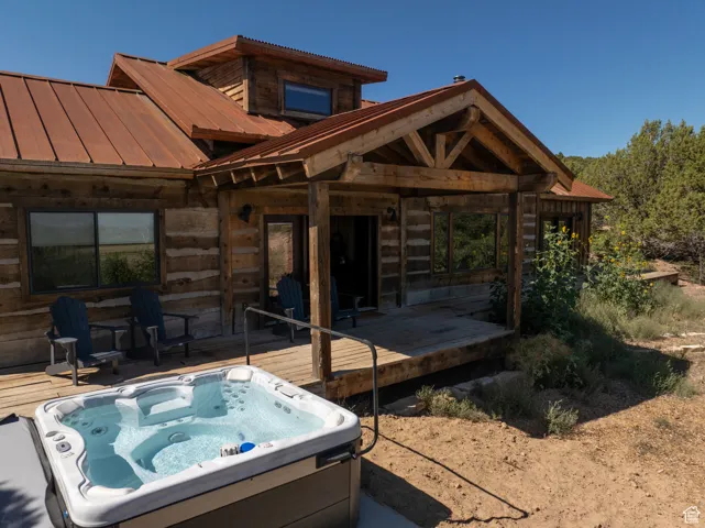 View of patio / terrace featuring an outdoor hot tub and a wooden deck