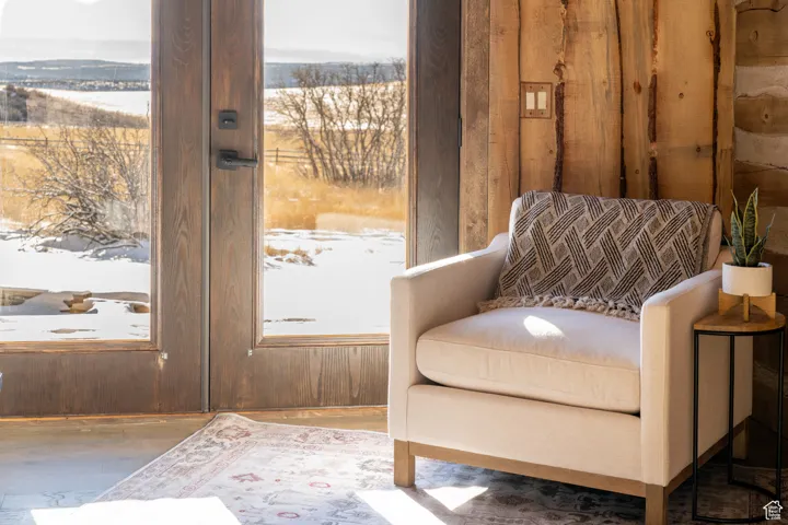 Sitting room with wooden walls, wood finished floors, and plenty of natural light