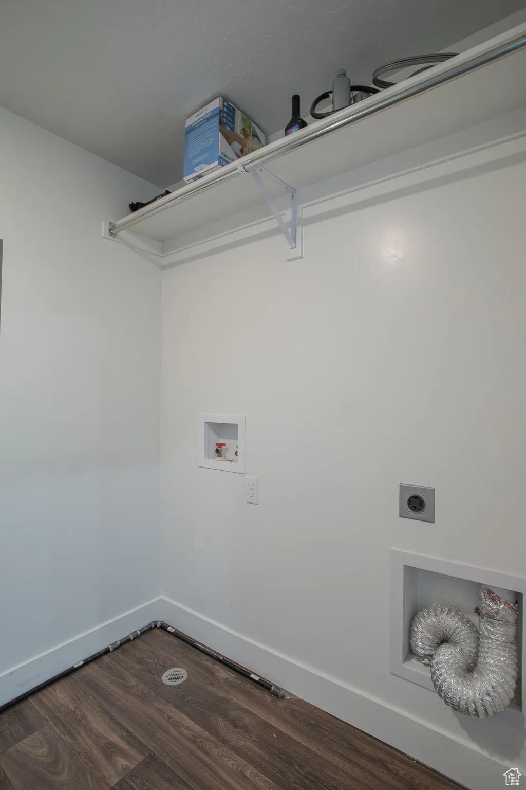 Laundry area featuring dark wood finished floors, hookup for a washing machine, and electric dryer hookup