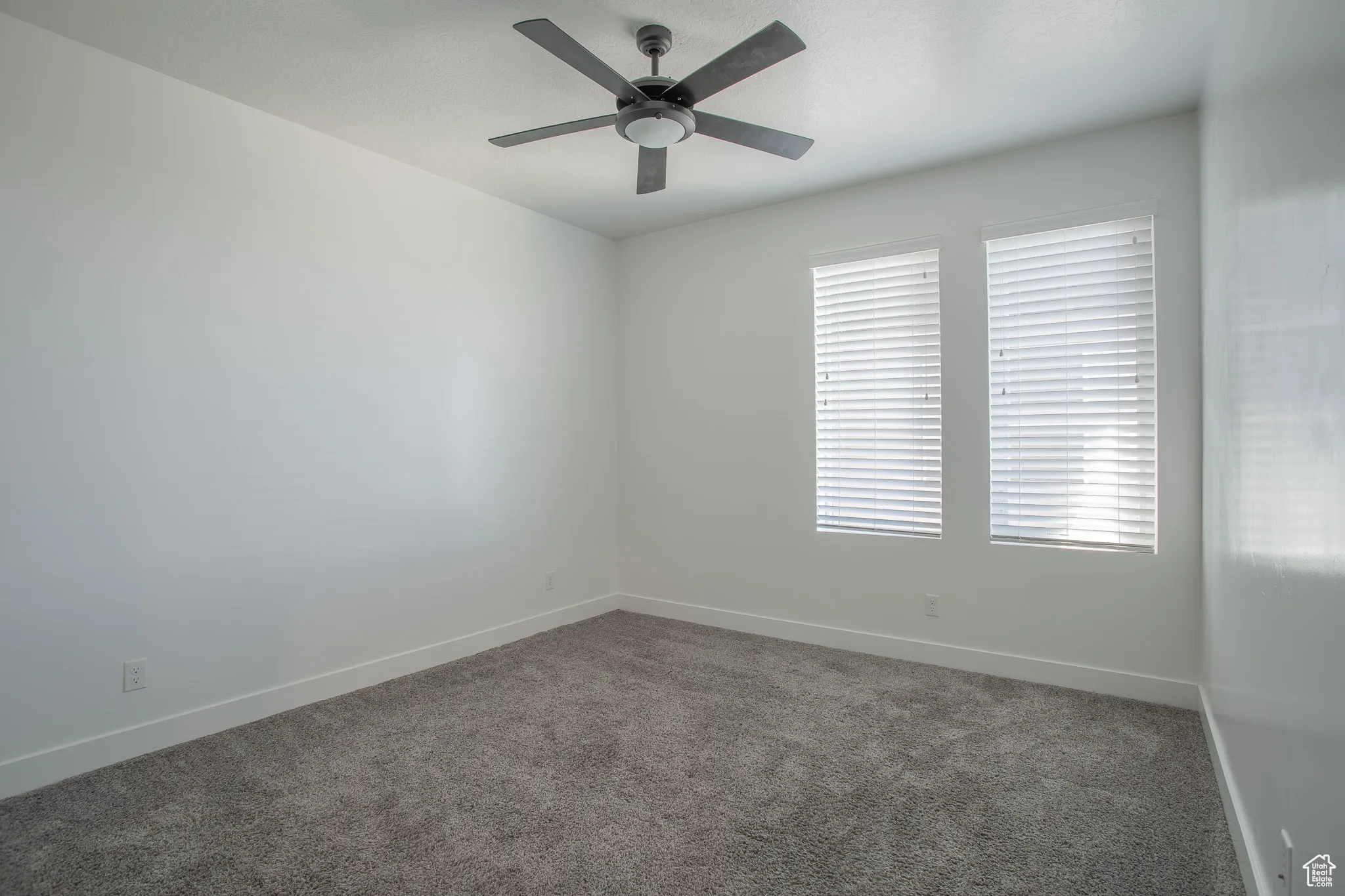 Empty room featuring carpet and a ceiling fan