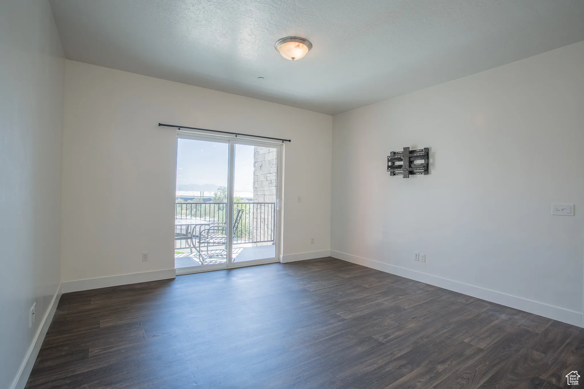 Unfurnished room with dark wood-type flooring
