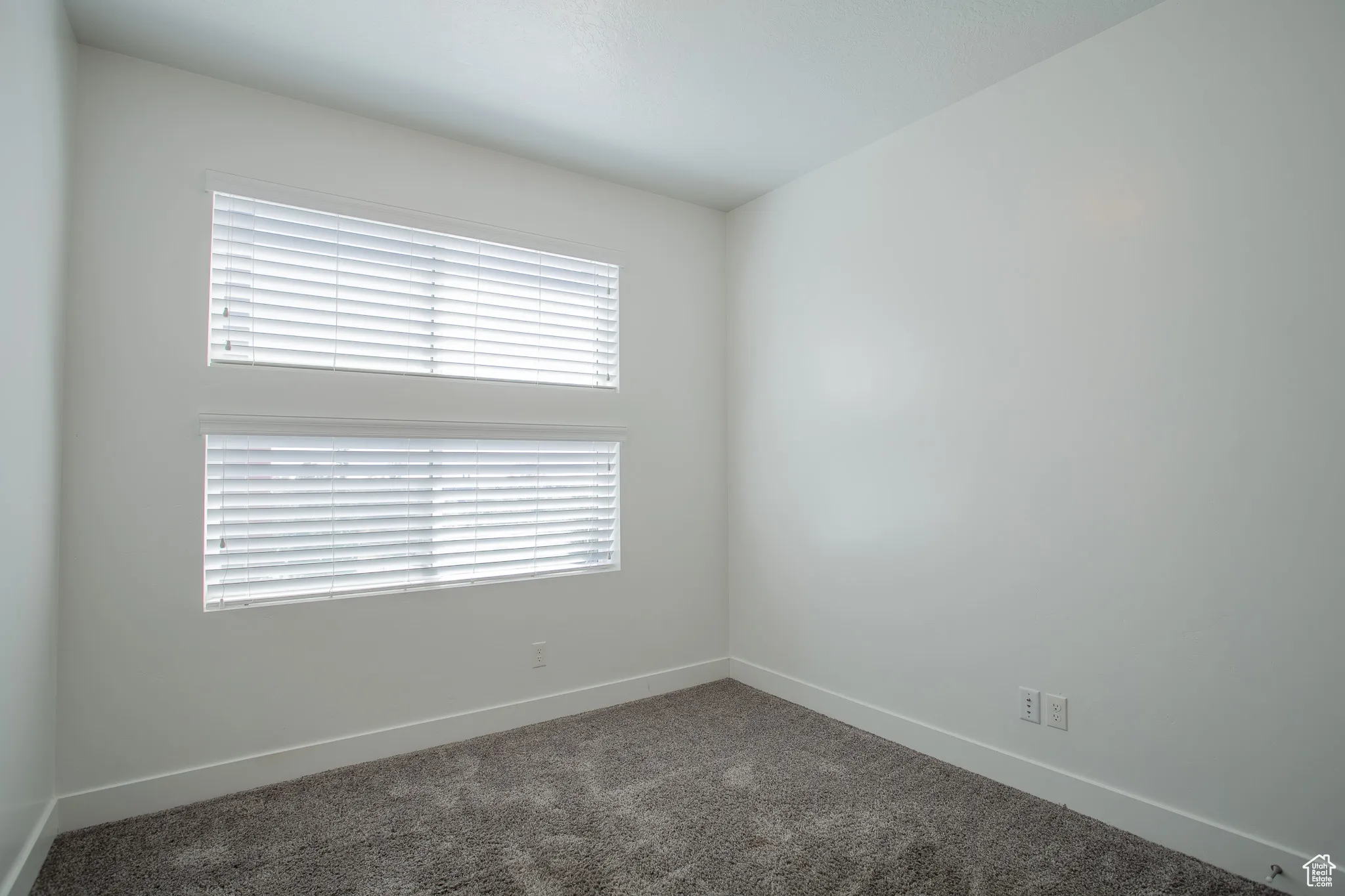 Carpeted empty room featuring baseboards