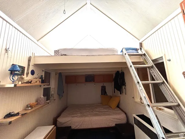 Bedroom with heating unit and vaulted ceiling