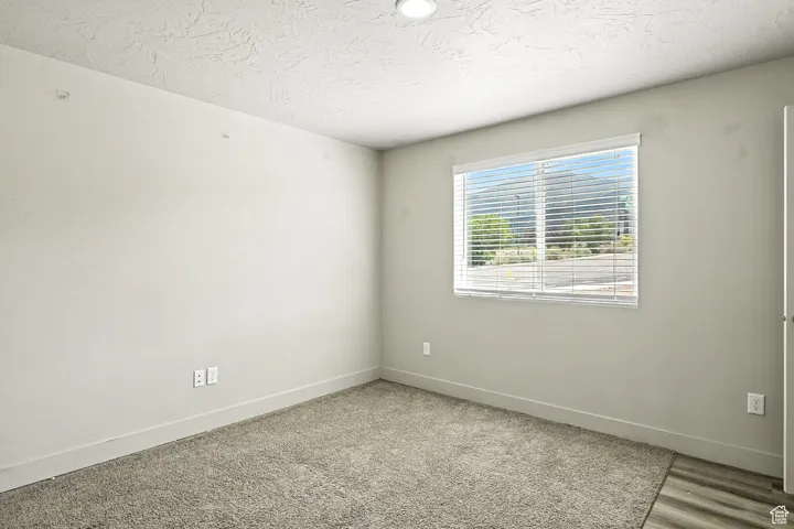 Unfurnished room featuring a textured ceiling and baseboards
