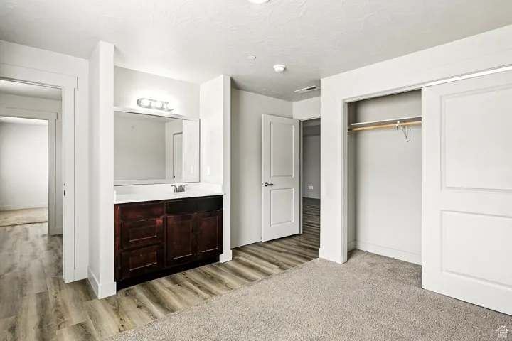 Bathroom with vanity, a textured ceiling, and light wood finished floors