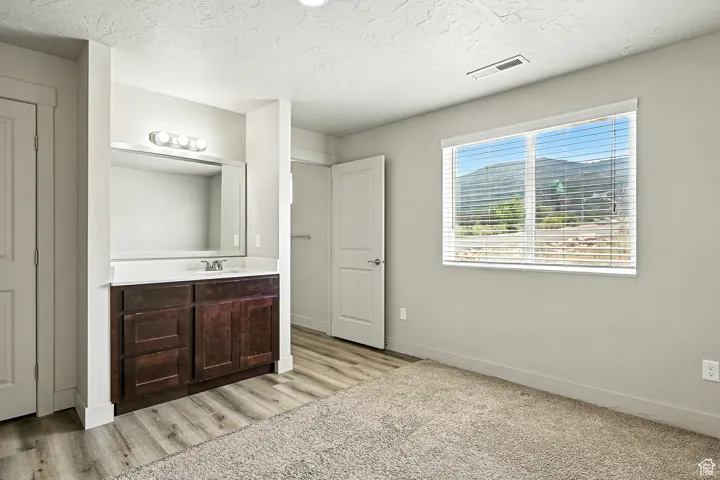 Bathroom featuring vanity, a textured ceiling, and light wood-style flooring